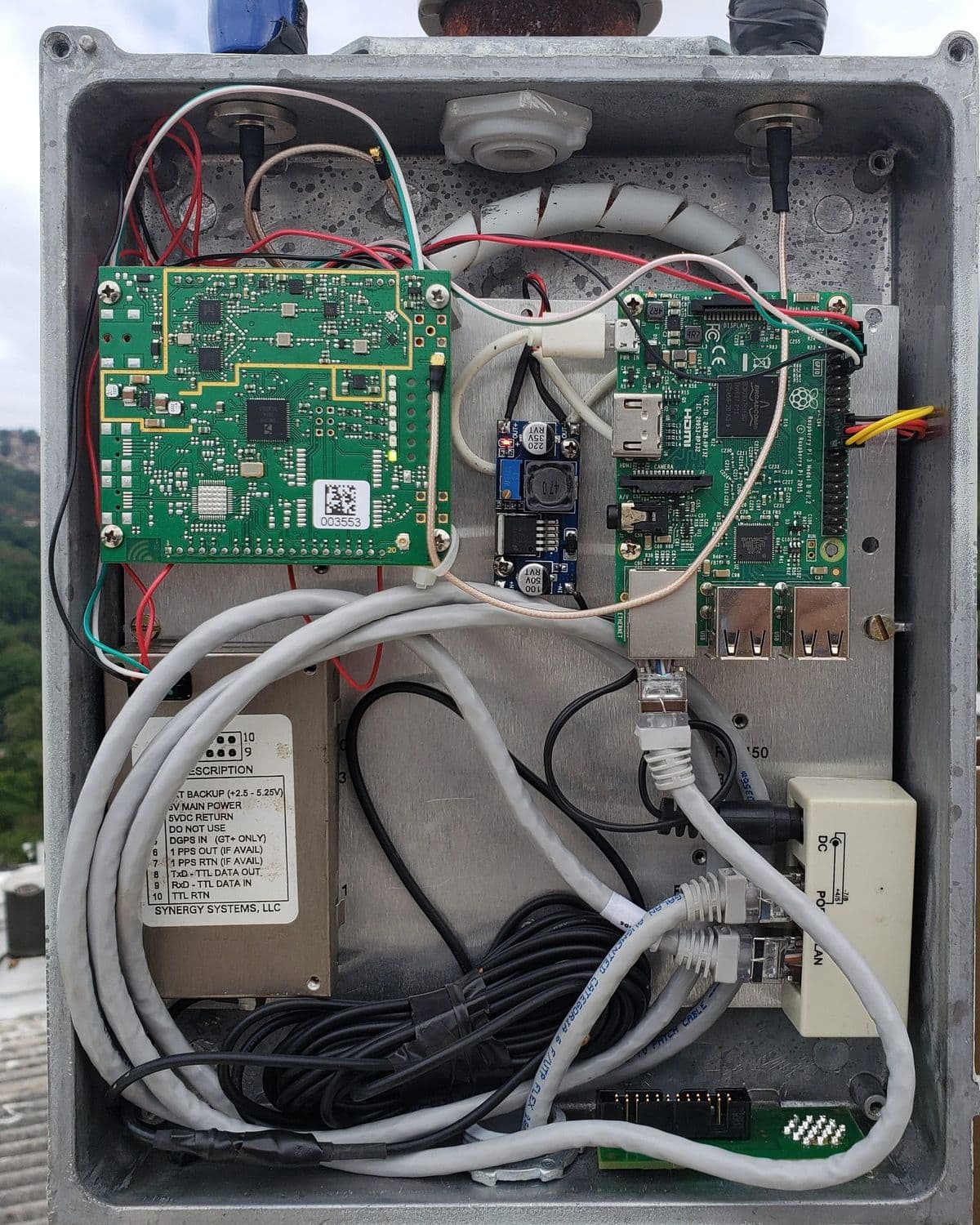 Equipo de telemetría instalado por BYTEM en una azotea: caja de aluminio estanca abierta, con la tarjeta de radio, una Raspberry Pi, el GPS y la alimentación por PoE.